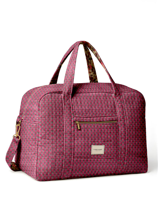Brown quilted duffle bag with paisley pattern, front zip pocket, dual handles, and label reading "I was a sari"
