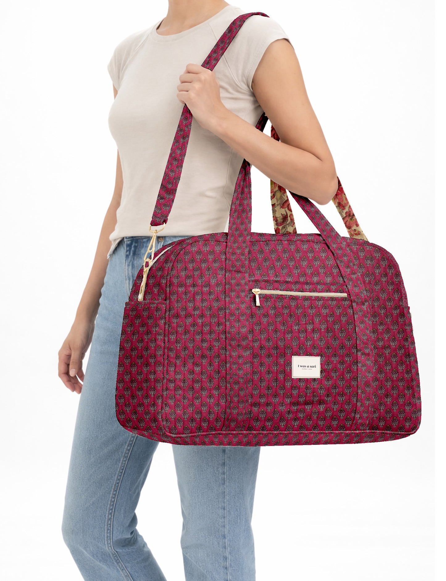 Brown quilted duffle bag with paisley pattern, front zip pocket, dual handles, and label reading "I was a sari"