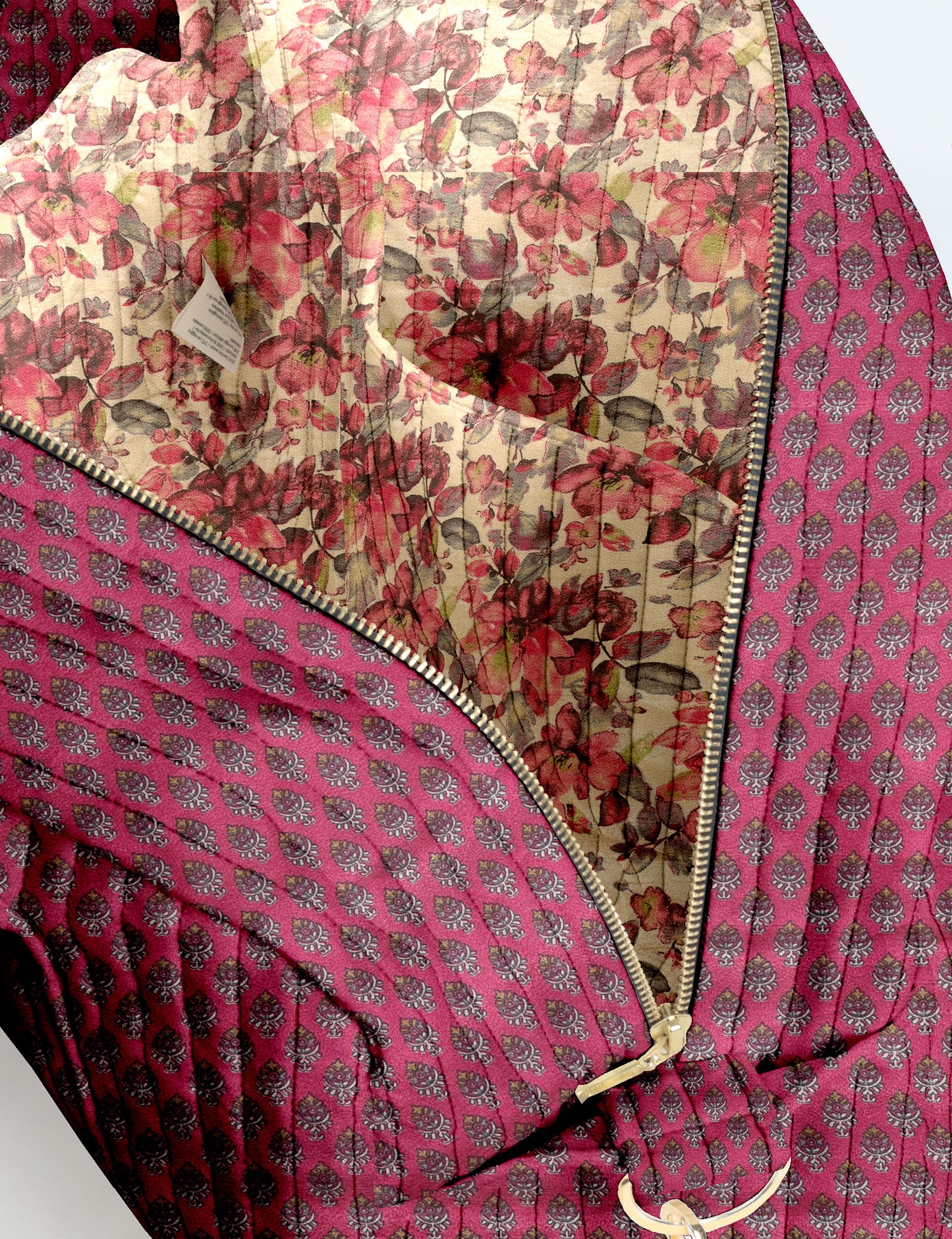 Brown quilted duffle bag with paisley pattern, front zip pocket, dual handles, and label reading "I was a sari"