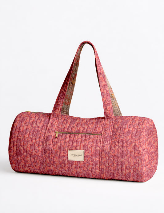 Beige quilted bowling bag with micro floral pattern, front zipper pocket, and dual handles with striped inner lining