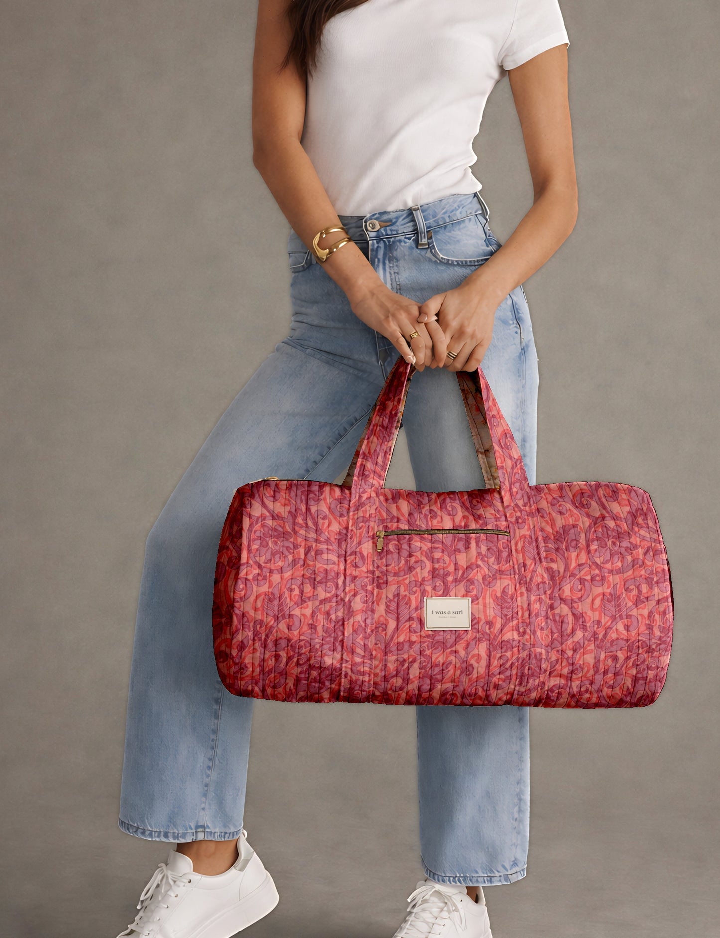 Beige quilted bowling bag with micro floral print exterior and blue geometric patterned interior, open zipper view