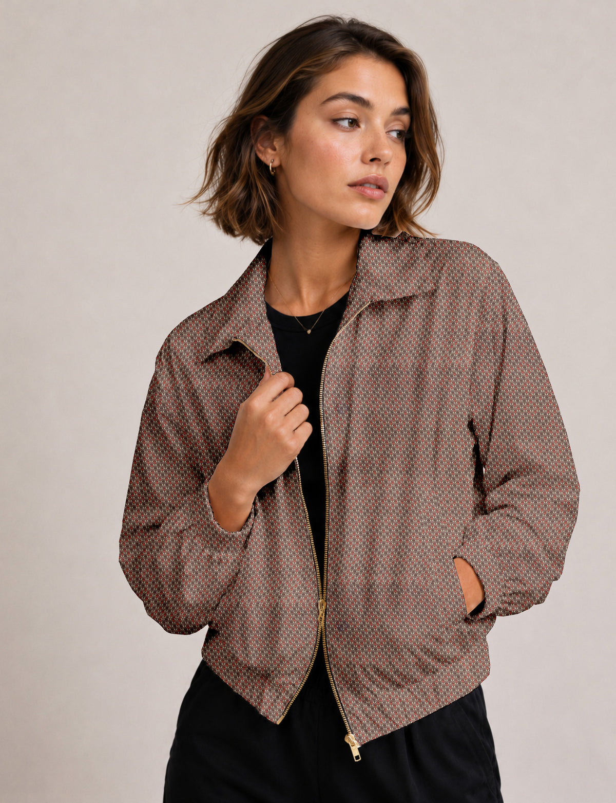 Brown floral bomber jacket with front zipper, elastic cuffs and hem, hanging on white hanger, red floral inner lining visible