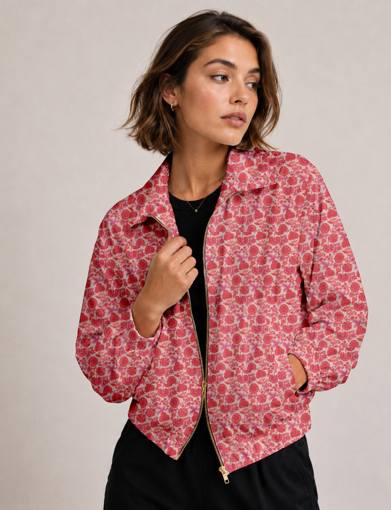 Woman wearing a yellow floral bomber jacket with front zipper, elastic cuffs, and side pockets, shown from front view