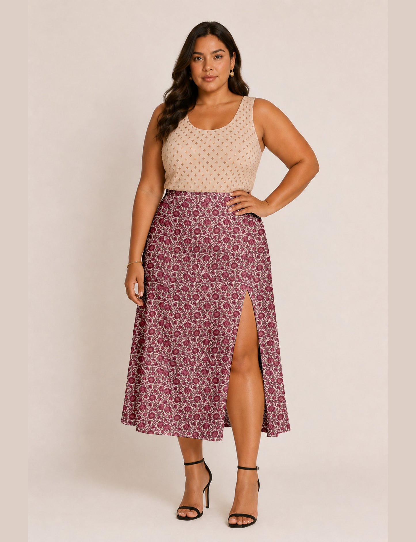 Woman wearing a yellow and black micro patterned A-line skirt with front slit, paired with beige sleeveless top and black
