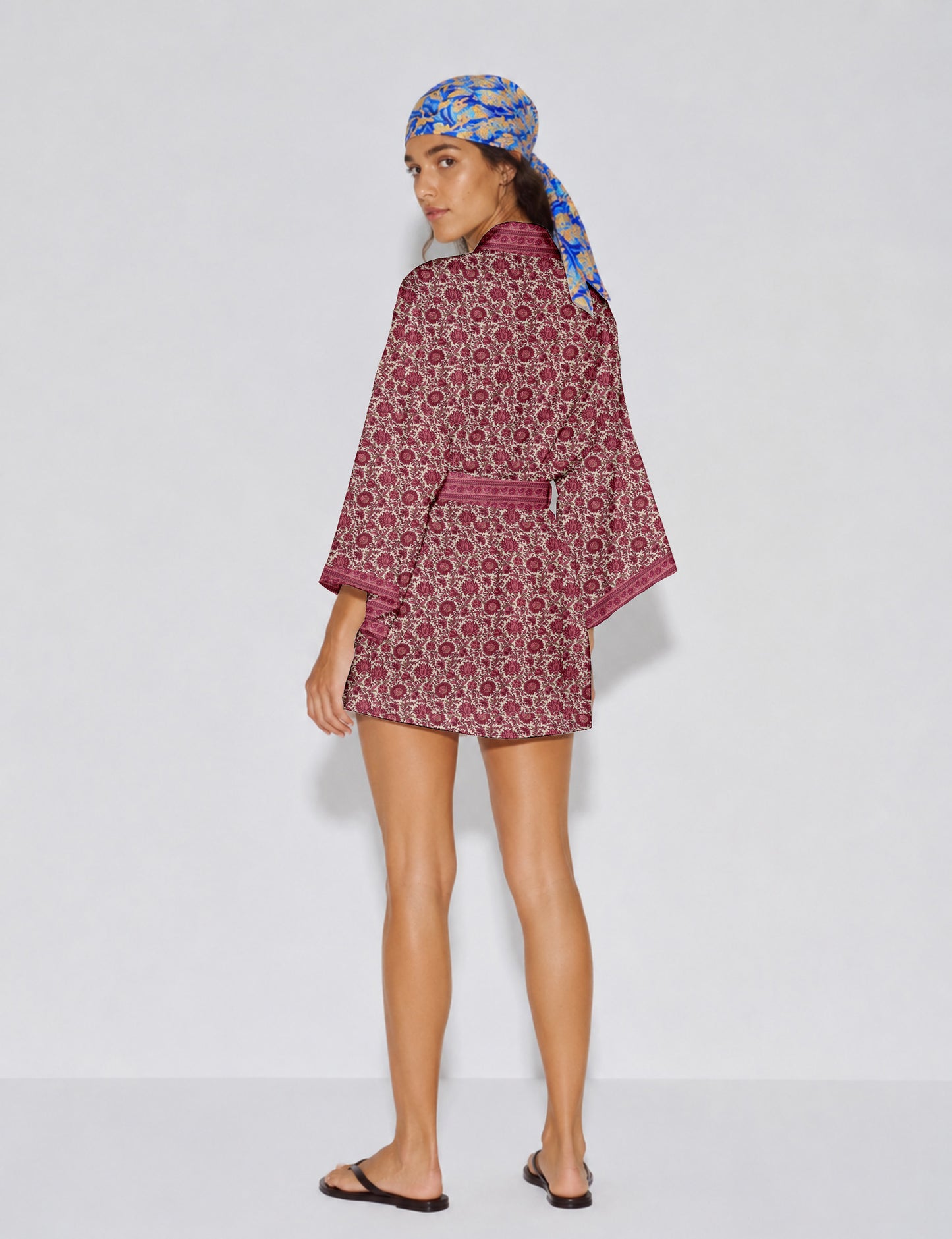 Short kimono robe with wrap front, V-neckline, wide sleeves, waist tie, and concealed skort detail.