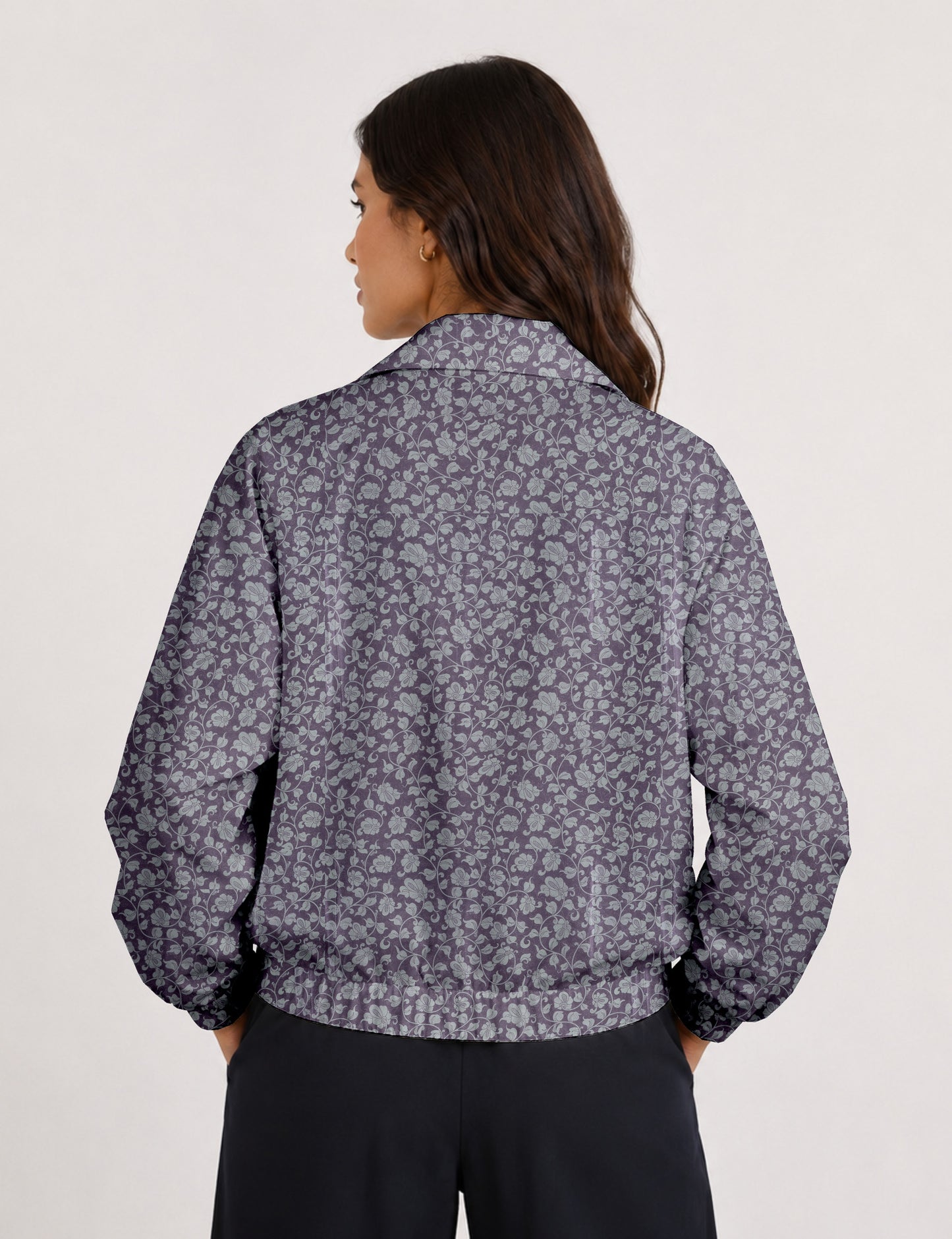 Woman wearing a yellow floral bomber jacket with front zipper, elastic cuffs, and side pockets, shown from front view