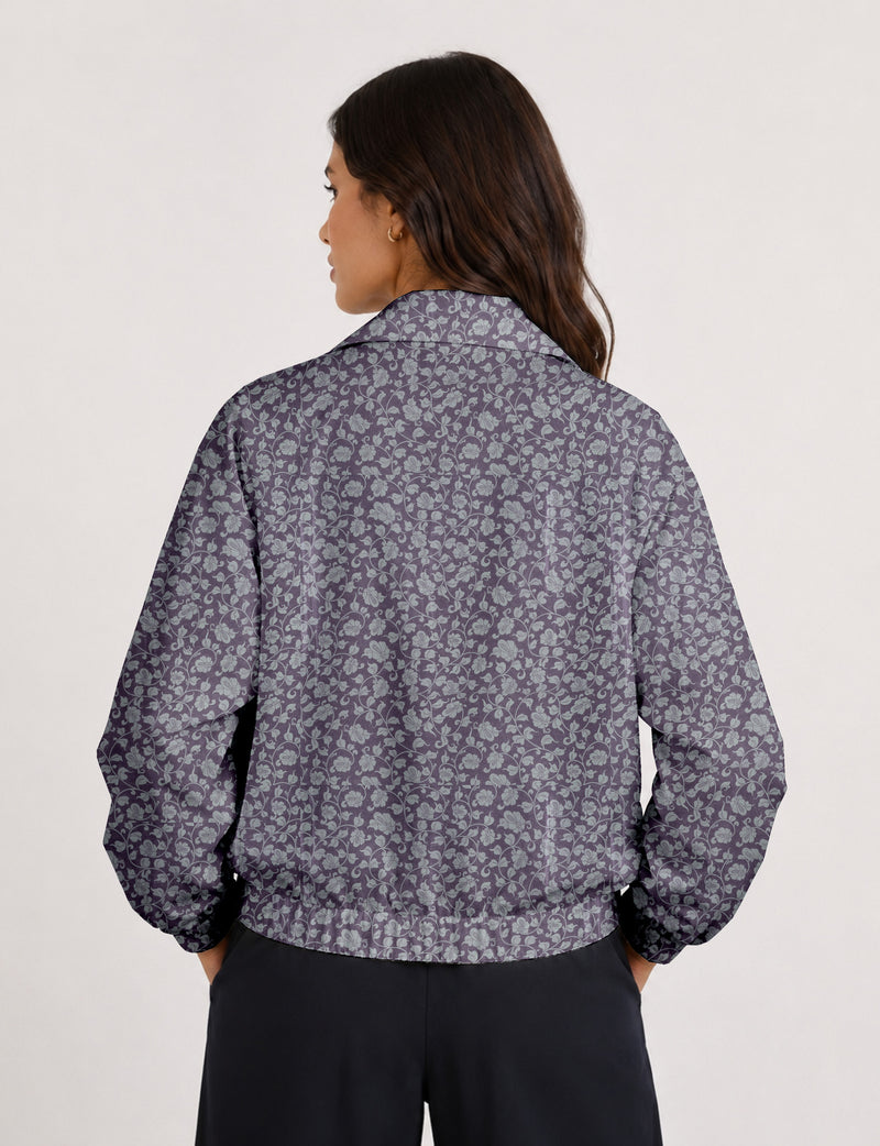 Woman wearing a yellow floral bomber jacket with front zipper, elastic cuffs, and side pockets, shown from front view