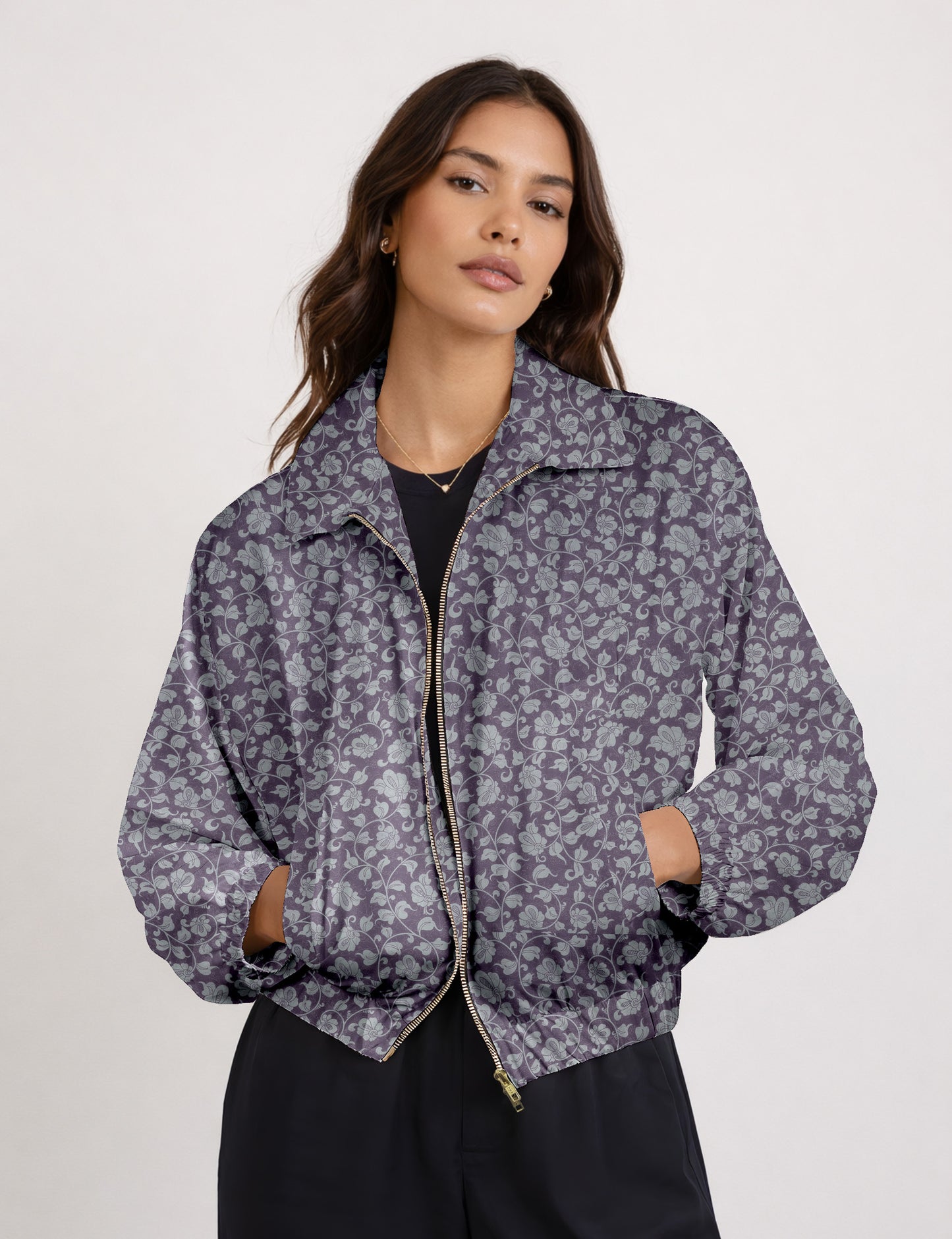 Brown floral bomber jacket with front zipper, elastic cuffs and hem, hanging on white hanger, red floral inner lining visible