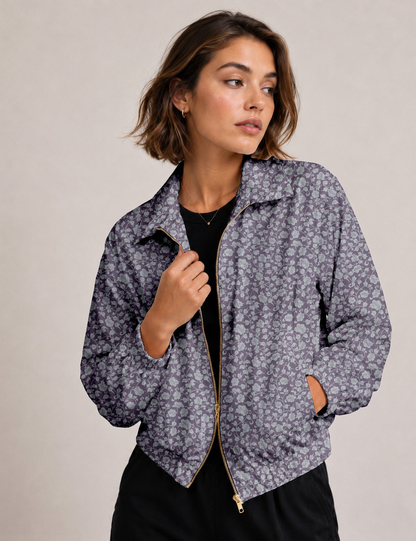 Woman wearing a yellow floral bomber jacket with front zipper, elastic cuffs, and side pockets, shown from front view