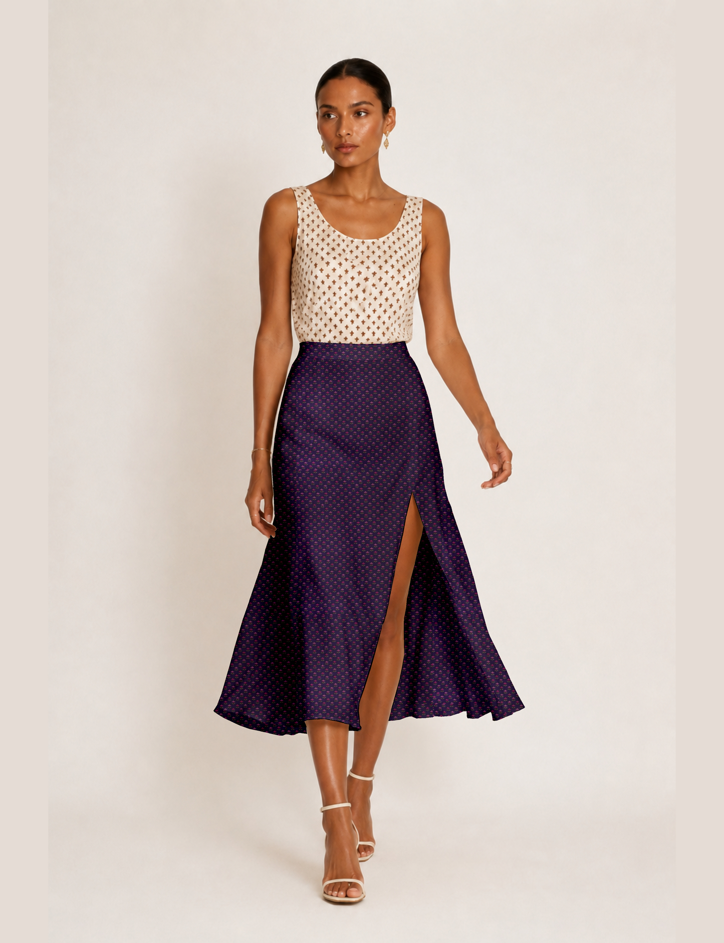 Woman wearing a yellow and black micro patterned A-line skirt with front slit, paired with beige sleeveless top and black