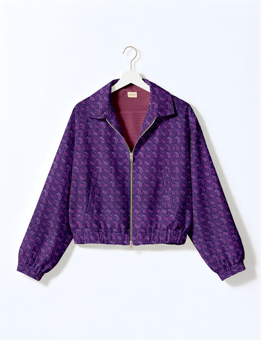 Yellow bomber jacket with micro geometric pattern, silver front zipper, elastic cuffs, and blue floral inner lining, hanging