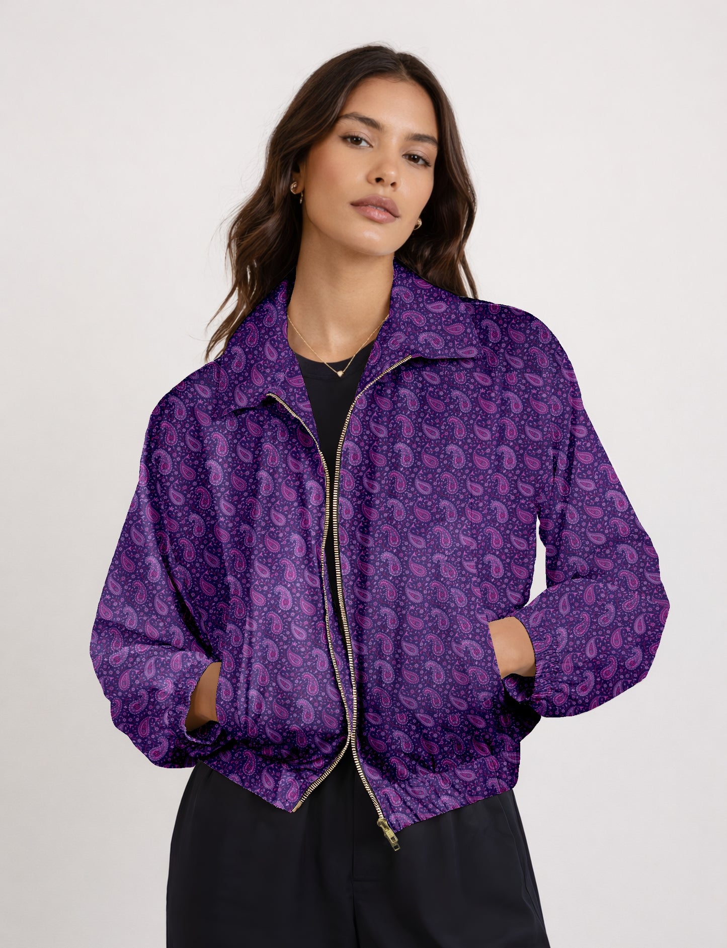 Woman wearing a yellow bomber jacket with a micro geometric pattern, front zipper, and side pockets, paired with black pants
