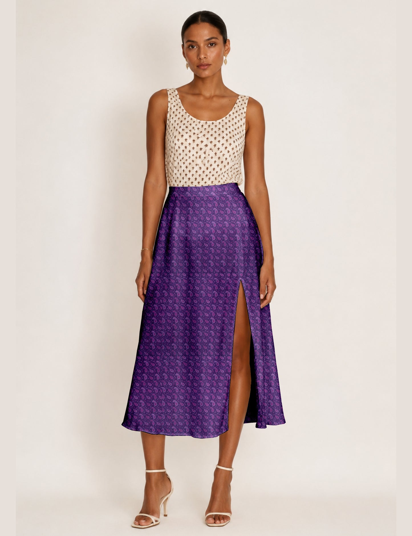 Woman wearing a yellow micro design A-line skirt with side slit, paired with a sleeveless beige top with small cross