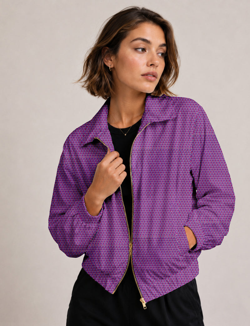Woman wearing a purple floral bomber jacket with gold zipper and collar, shown from front in a neutral background