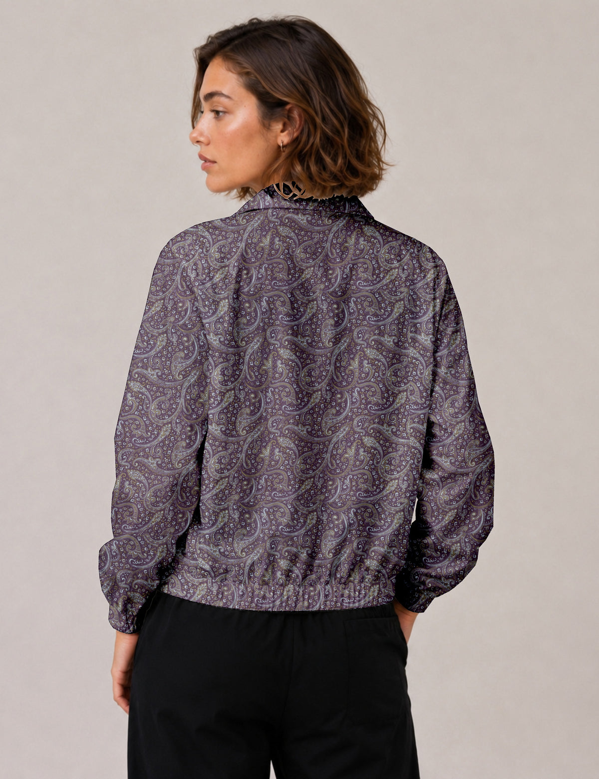 Woman wearing a yellow floral bomber jacket with front zipper, elastic cuffs, and side pockets, shown from front view