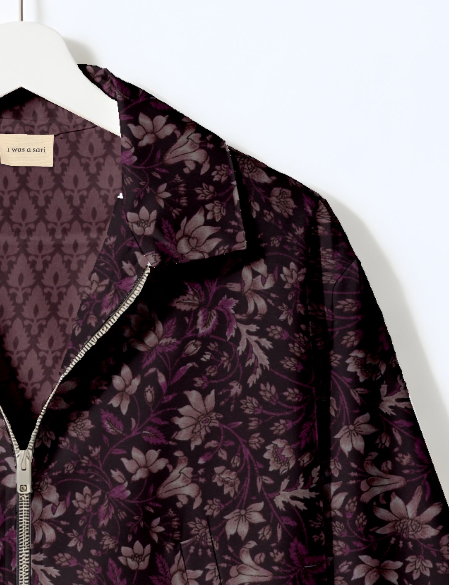 Women's cropped bomber jacket with twin metallic front zippers, welt pockets, elasticated hem and cuffs, and contrast sari print lining.