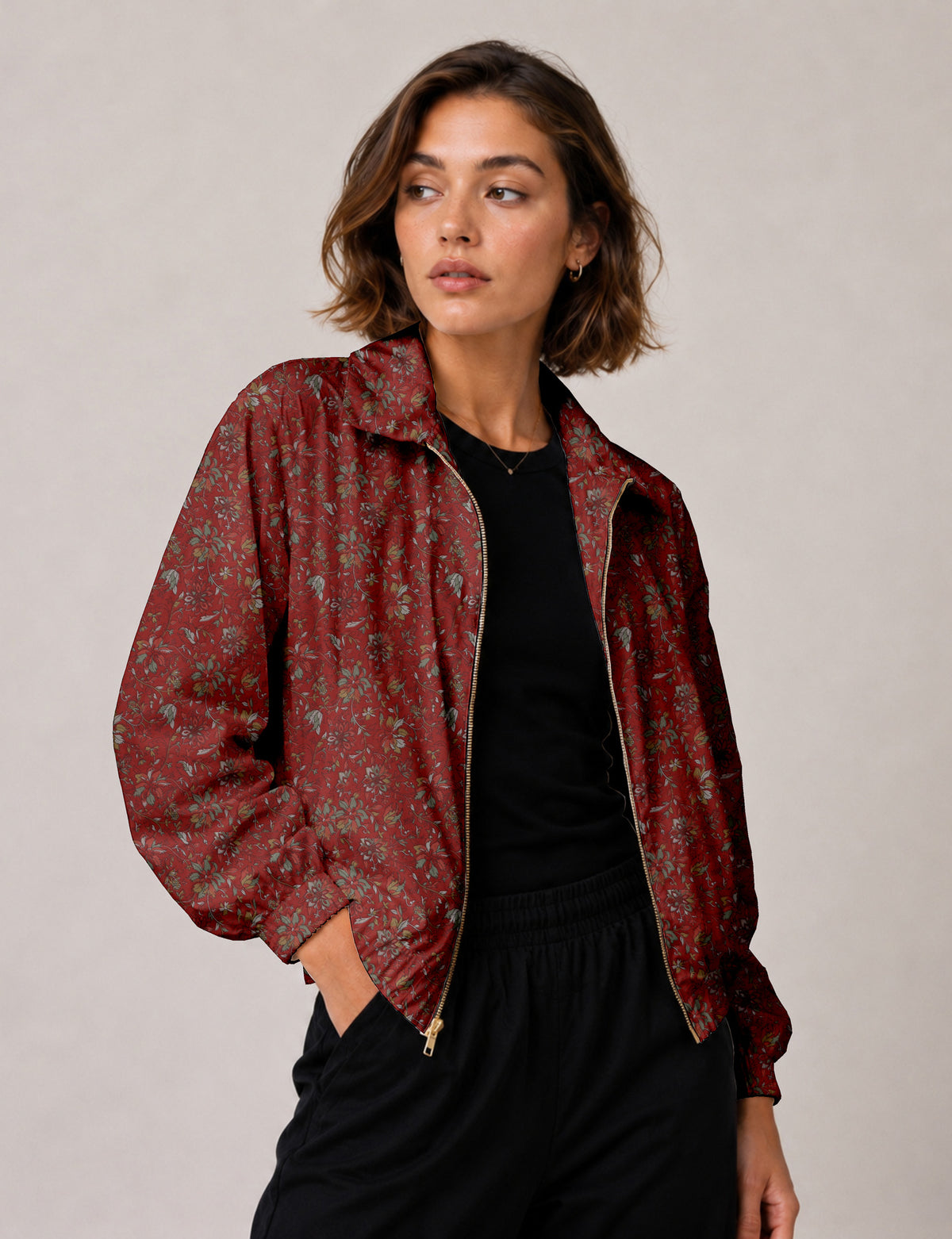 Woman wearing a yellow floral bomber jacket with front zipper, elastic cuffs, and side pockets, shown from front view