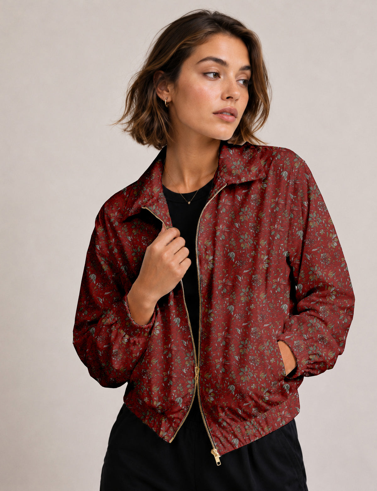 Woman wearing a yellow floral bomber jacket with front zipper, elastic cuffs, and side pockets, shown from front view