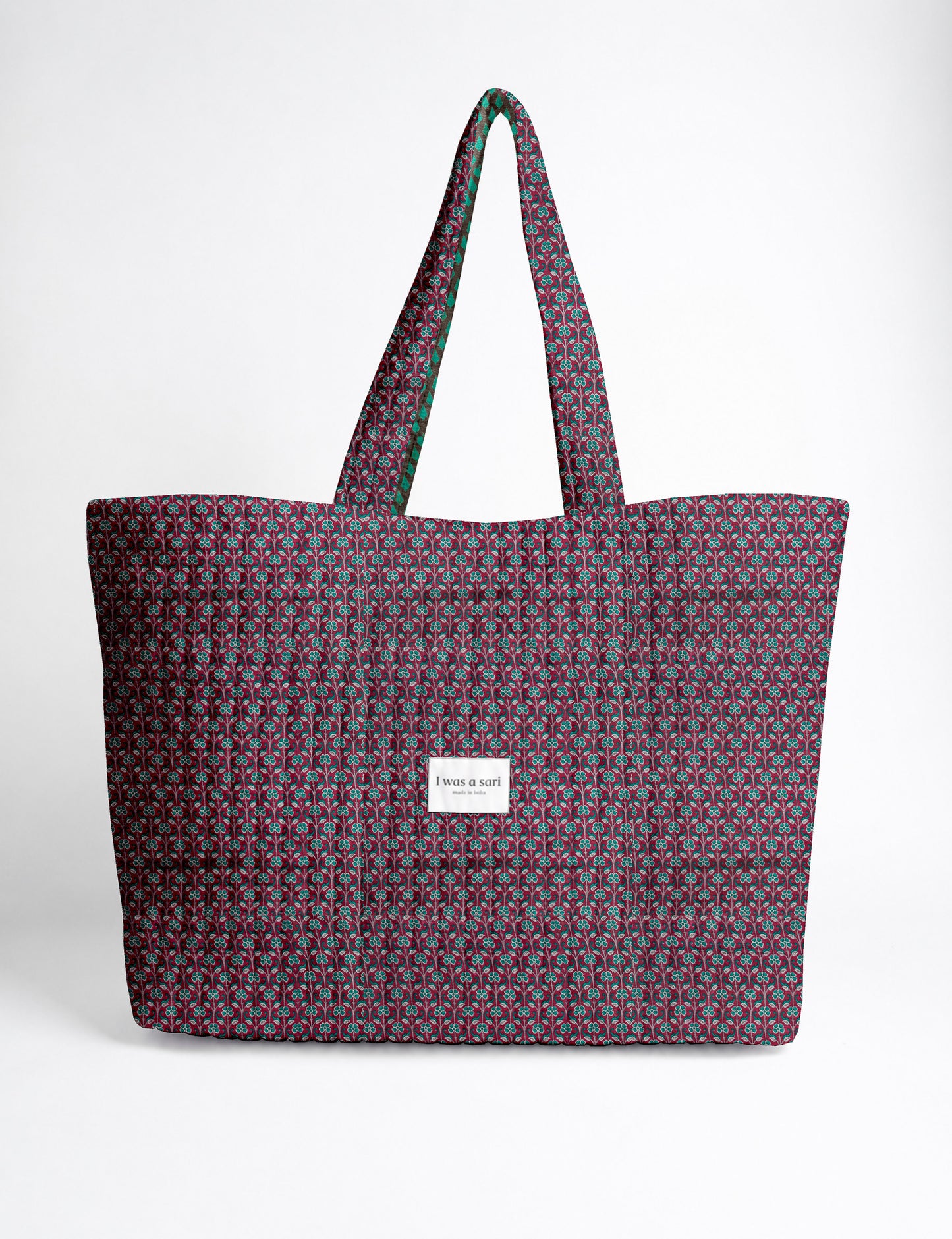 Quilted yellow tropical patterned beach bag with long handles and white label reading "I was a sari" front view