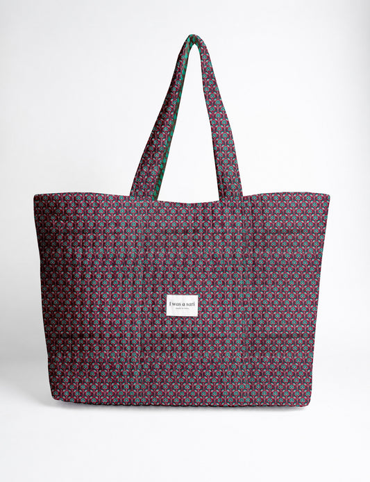 Quilted yellow tropical patterned beach bag with long handles and white label reading "I was a sari" front view