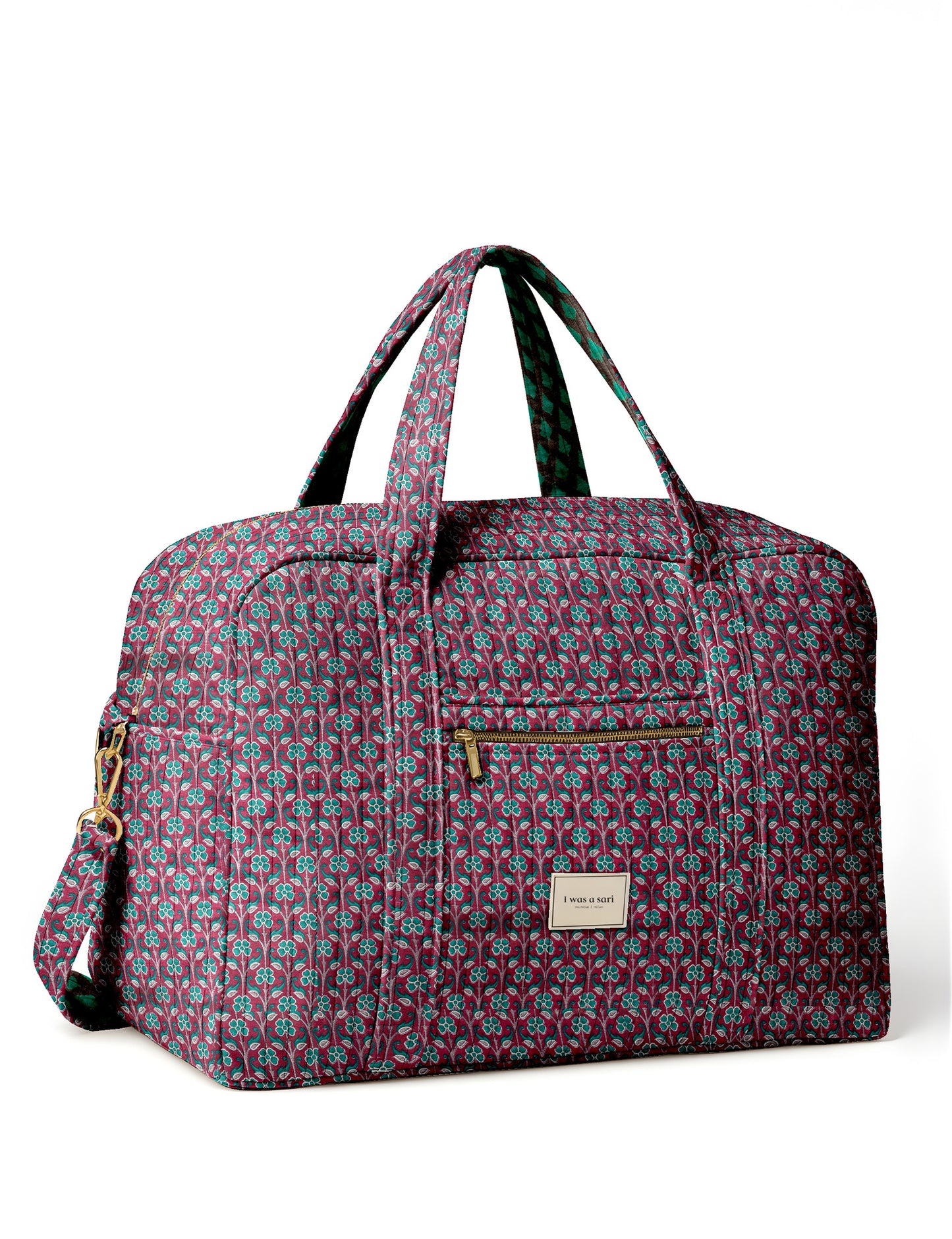 Brown quilted duffle bag with paisley pattern, front zip pocket, dual handles, and label reading "I was a sari"