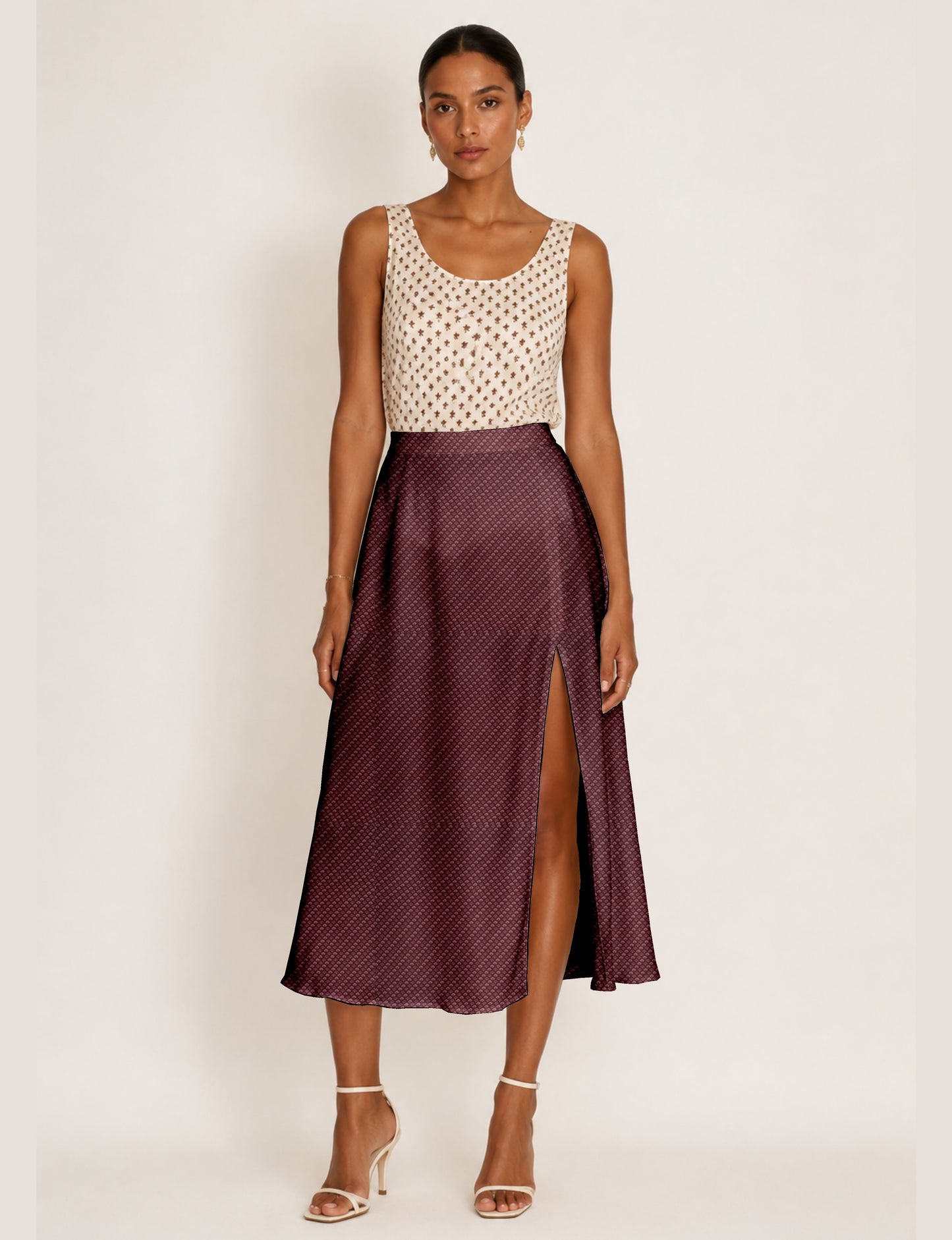 Woman wearing a yellow and navy blue A-line skirt with a slit and a sleeveless beige top with brown micro print