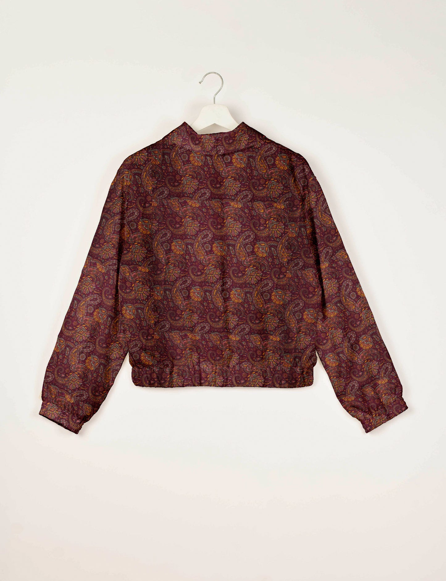 Red paisley patterned bomber jacket with elastic cuffs and waistband, shown from back on white hanger