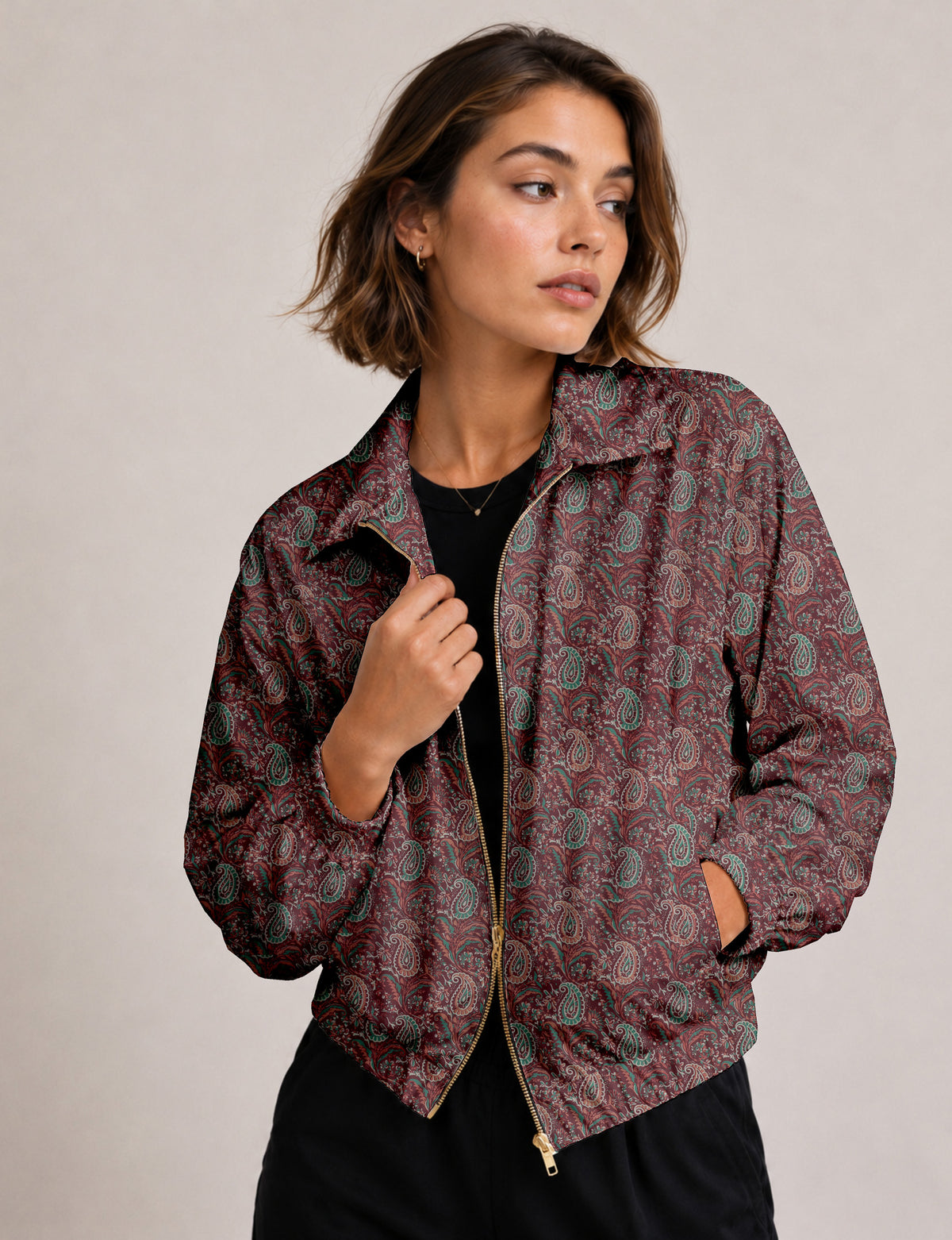 Brown floral bomber jacket with front zipper, elastic cuffs and hem, hanging on white hanger, red floral inner lining visible
