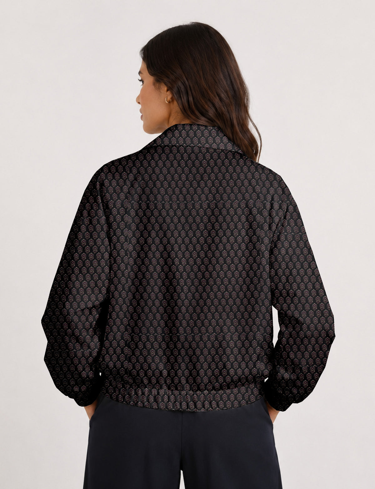 Brown floral bomber jacket with front zipper, elastic cuffs and hem, hanging on white hanger, red floral inner lining visible