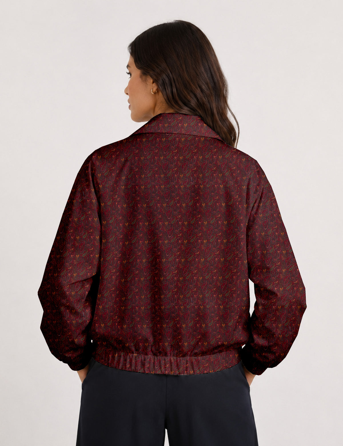 Woman wearing a yellow floral bomber jacket with front zipper, elastic cuffs, and side pockets, shown from front view