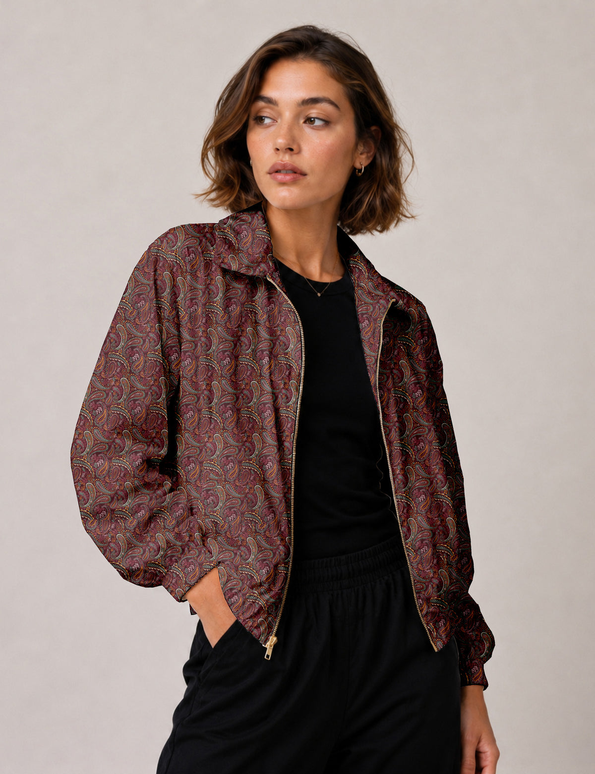 Woman wearing a yellow floral bomber jacket with front zipper, elastic cuffs, and side pockets, shown from front view