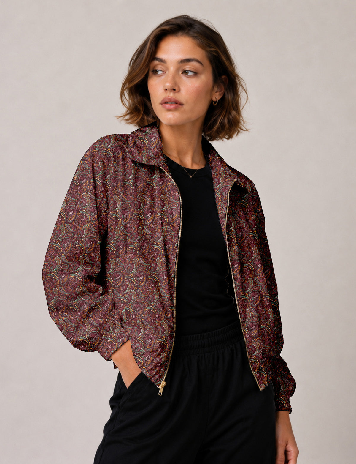 Brown floral bomber jacket with front zipper, elastic cuffs and hem, hanging on white hanger, red floral inner lining visible