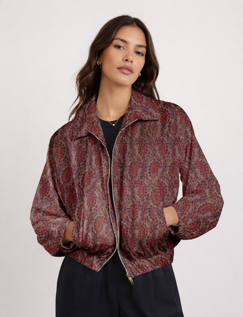 Woman wearing a yellow floral bomber jacket with front zipper, elastic cuffs, and side pockets, shown from front view