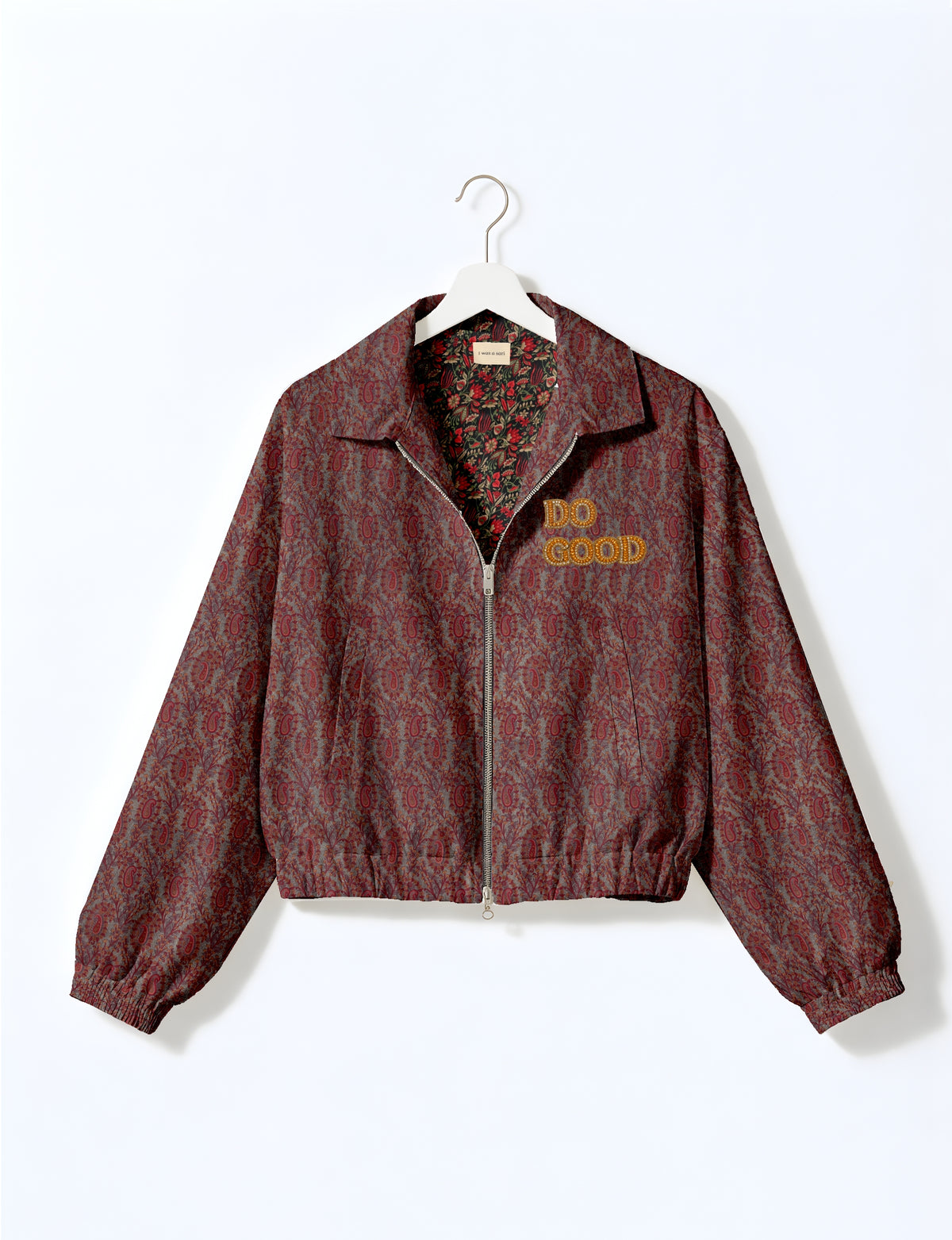 Gold cropped DO GOOD bomber jacket featuring hand-embroidered lettering on the left chest, contrasting inner lining and two functional pockets.