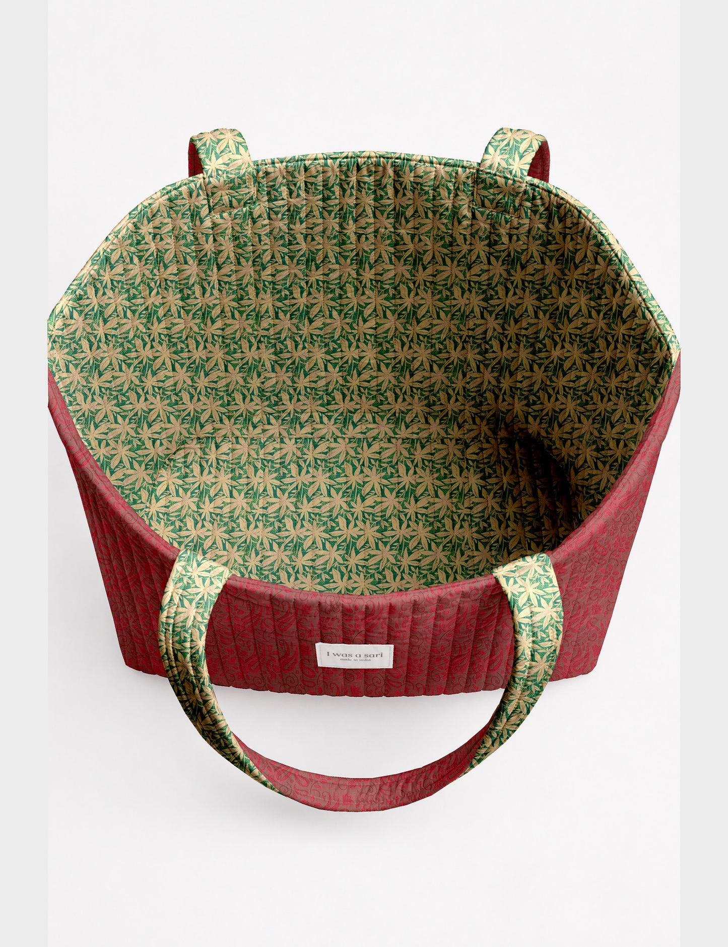 Quilted beach bag with yellow tropical exterior and red patterned interior, shown from top view with handles visible