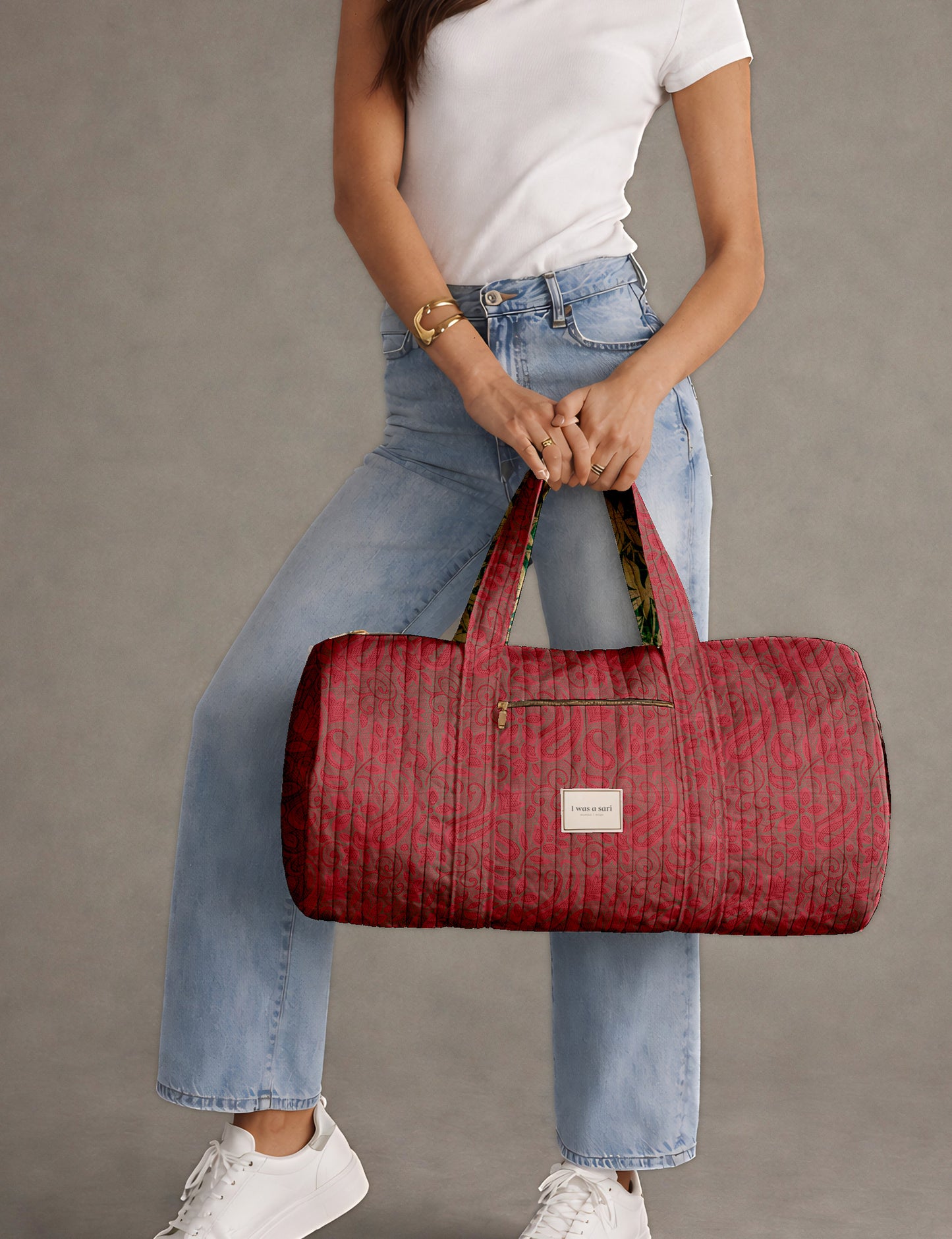 Brown paisley quilted bowling bag with dual handles, front zipper pocket, and "I was a sari" label on front side