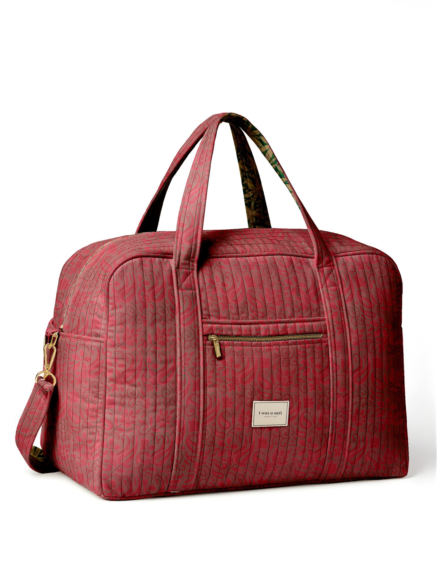 Brown quilted duffle bag with paisley pattern, front zip pocket, dual handles, and label reading "I was a sari"