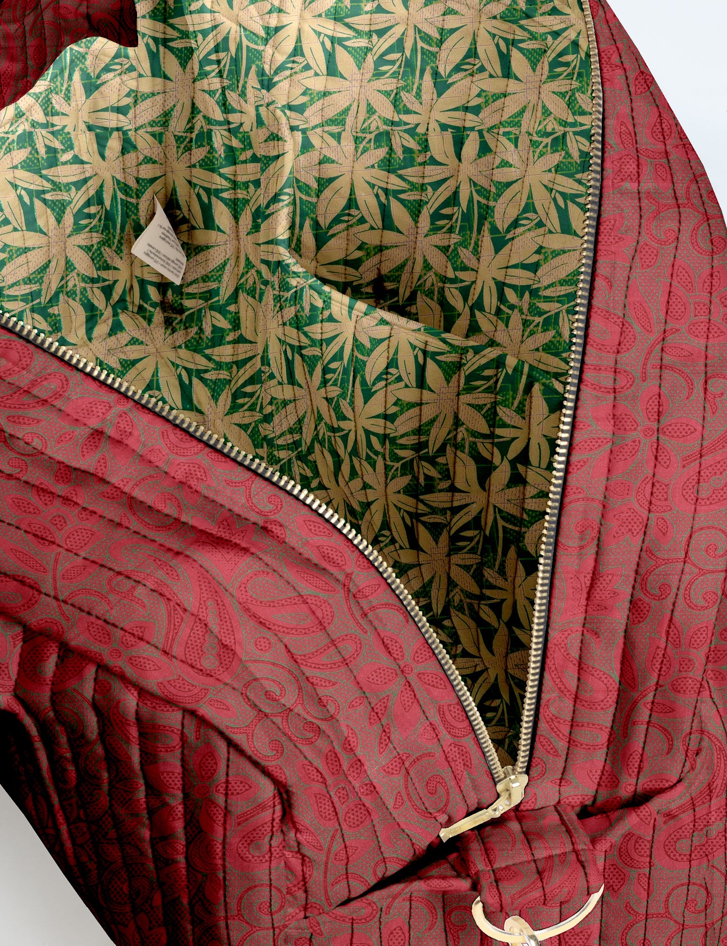 Brown quilted duffle bag with paisley pattern, front zip pocket, dual handles, and label reading "I was a sari"