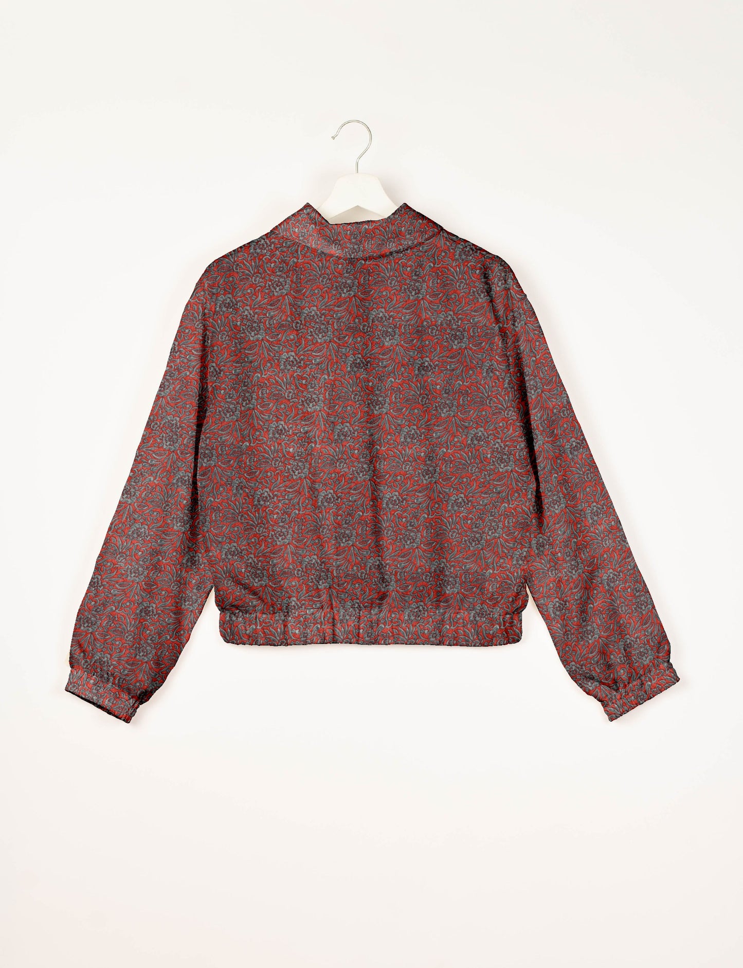 Red bomber jacket with gray floral tropical pattern, elastic cuffs and waistband, shown from back on white hanger