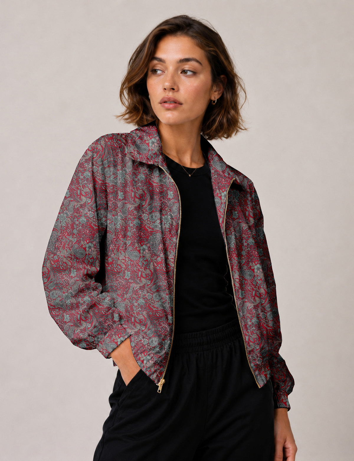Brown floral bomber jacket with front zipper, elastic cuffs and hem, hanging on white hanger, red floral inner lining visible