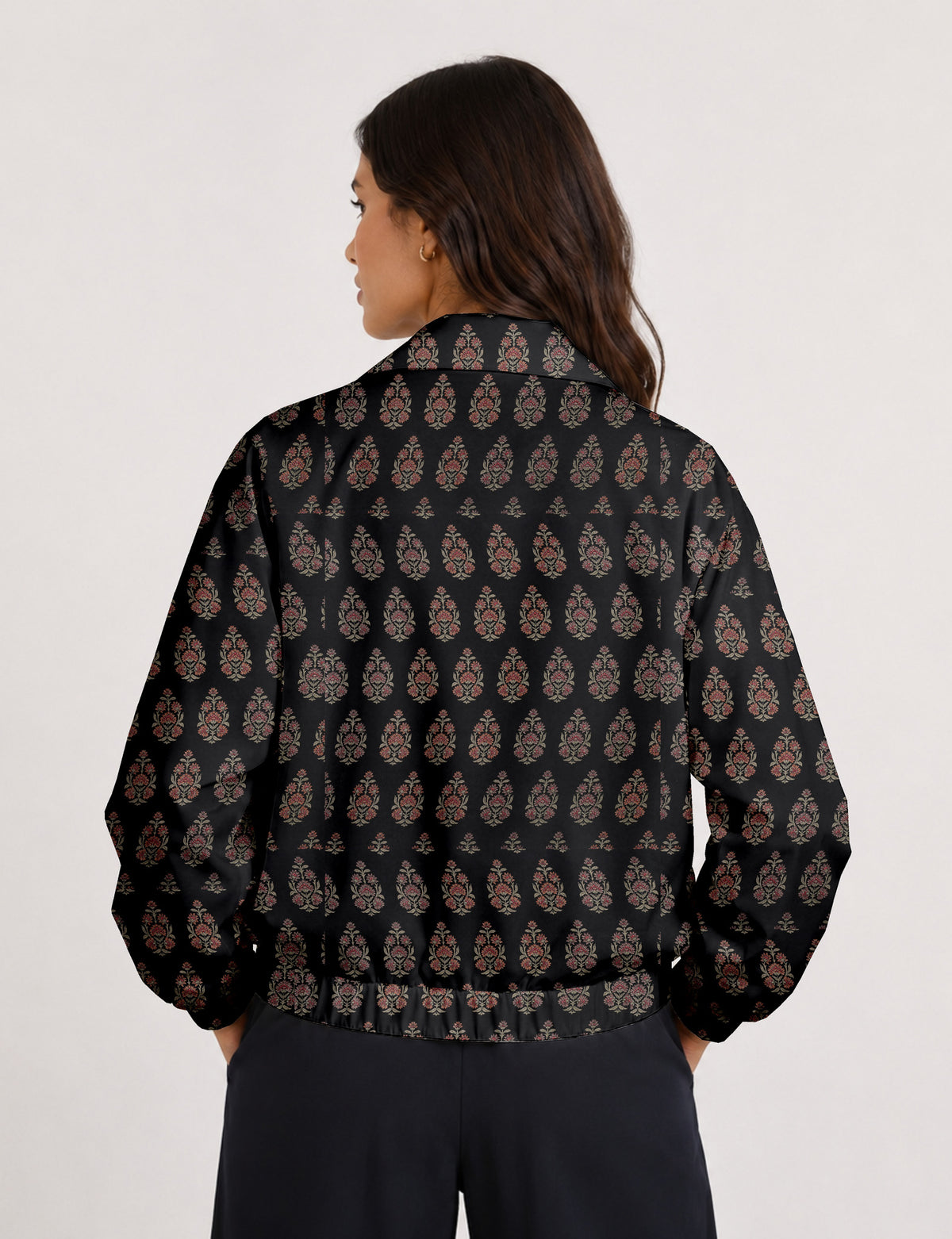 Woman wearing a yellow floral bomber jacket with front zipper, elastic cuffs, and side pockets, shown from front view