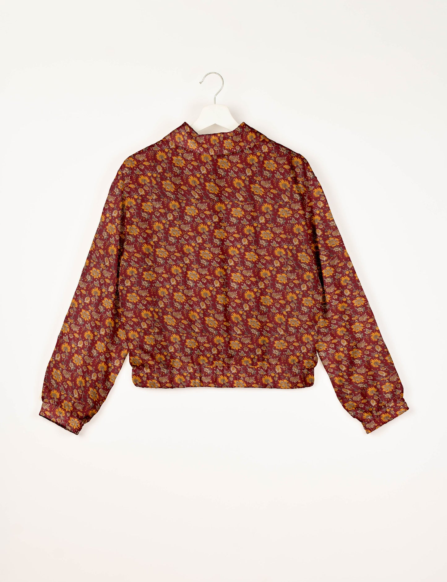 Red bomber jacket with yellow and orange floral tropical print, long sleeves, elastic cuffs and waistband, back view on