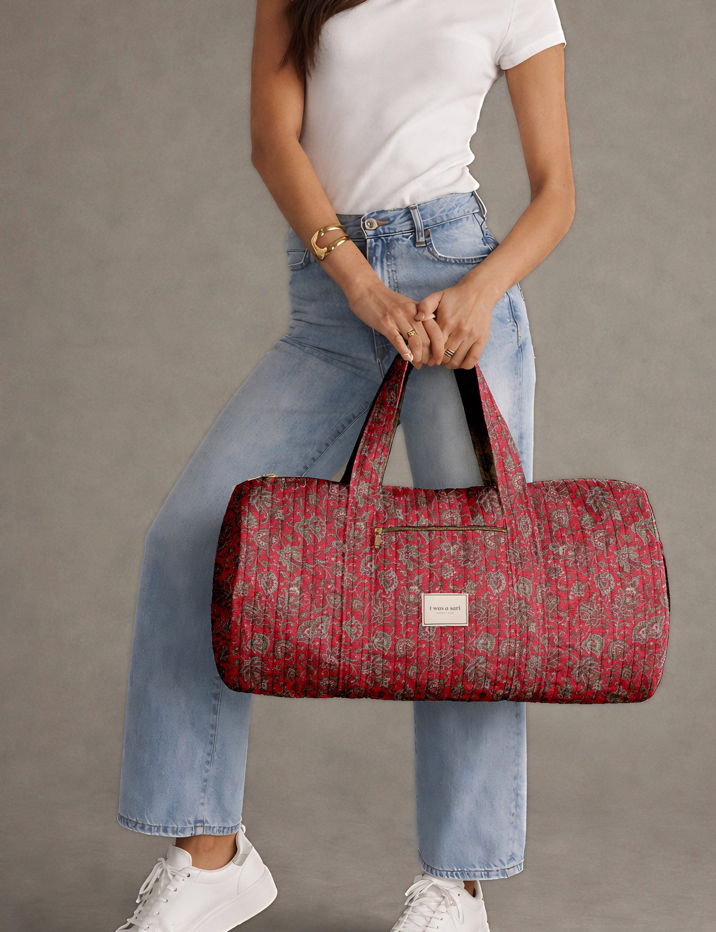 Brown paisley quilted bowling bag with dual handles, front zipper pocket, and "I was a sari" label on front side