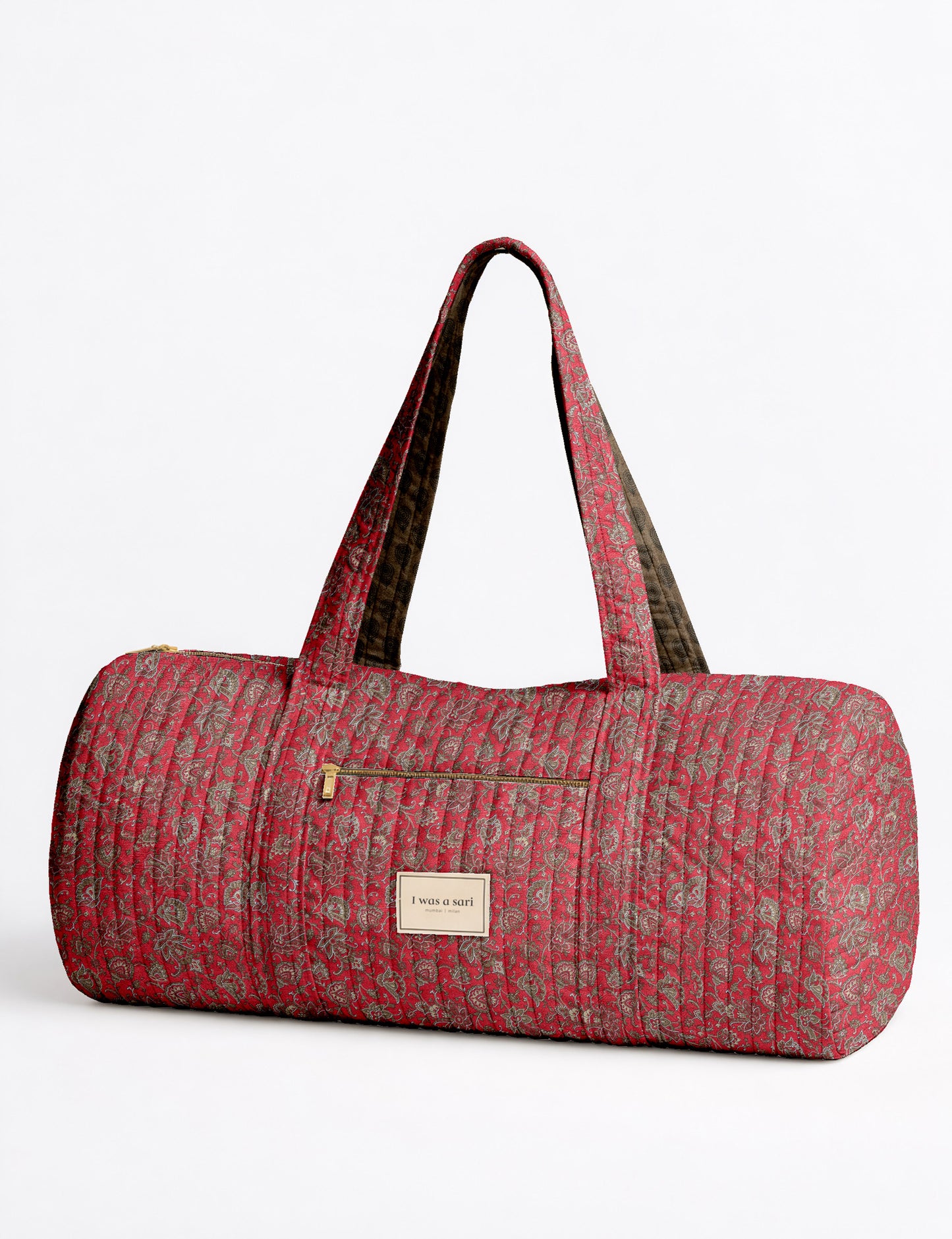 Brown paisley quilted bowling bag with dual handles, front zipper pocket, and "I was a sari" label on front side
