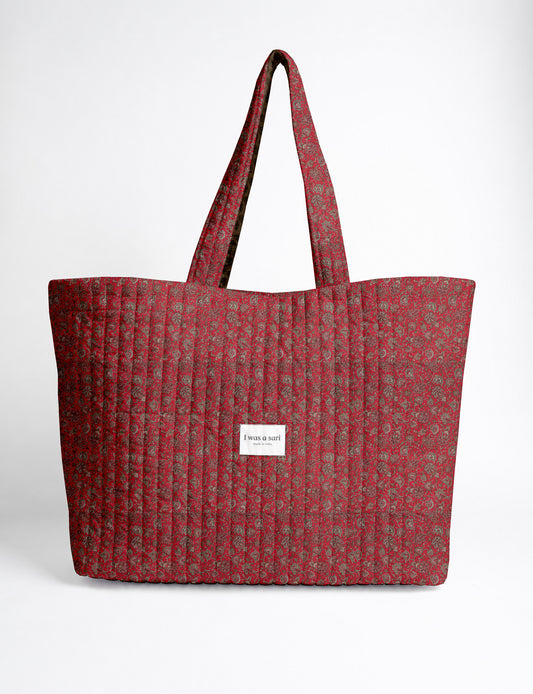 Quilted yellow tropical patterned beach bag with long handles and white label reading "I was a sari" front view