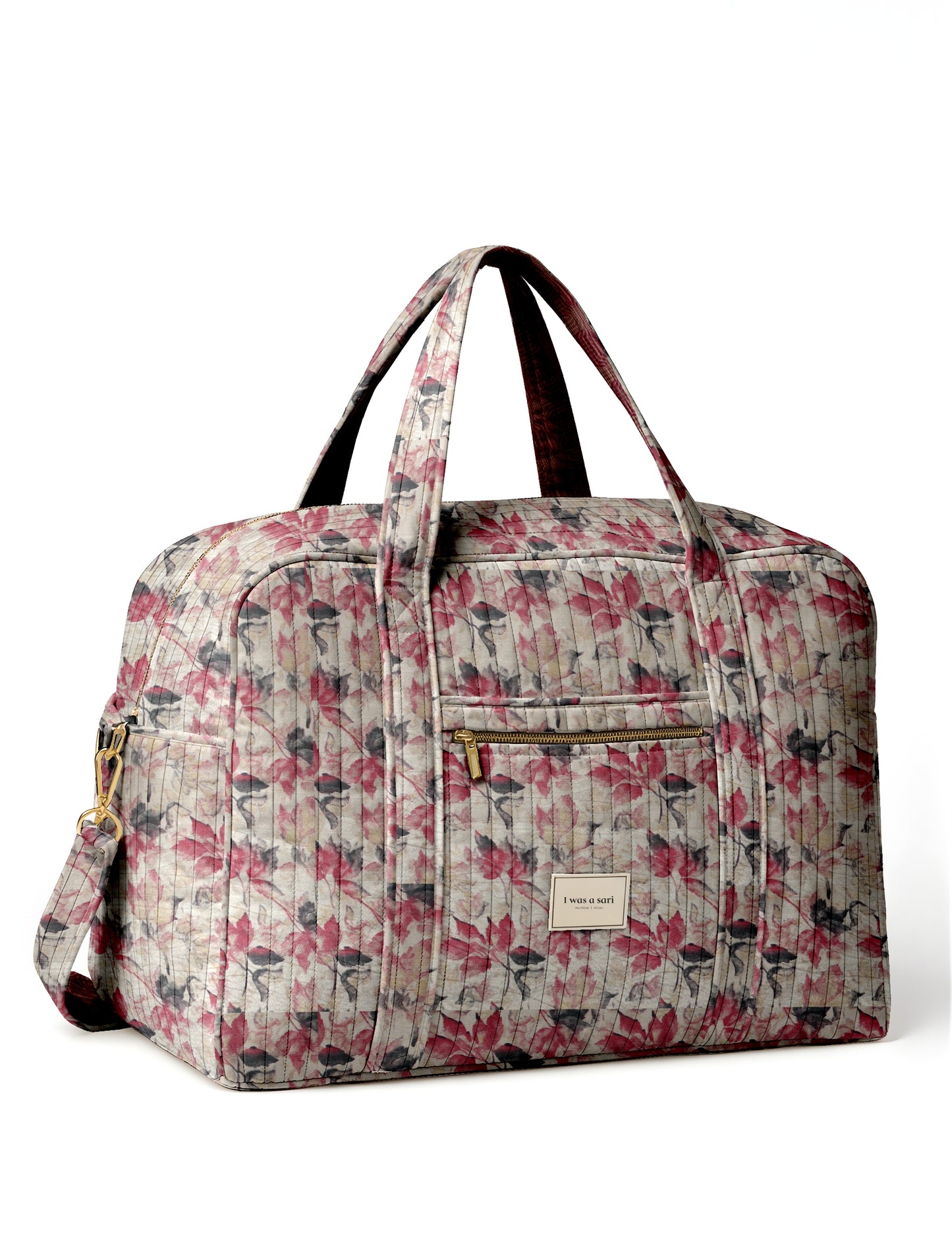 Quilted duffle bag with beige background and pink, gray leaf pattern, front zipper pocket, and dual handles, shown front