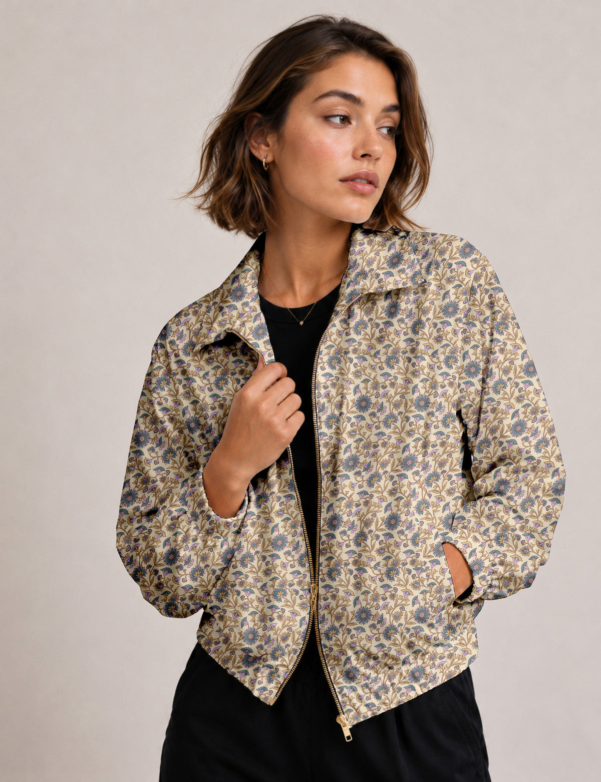 Brown floral bomber jacket with front zipper, elastic cuffs and hem, hanging on white hanger, red floral inner lining visible
