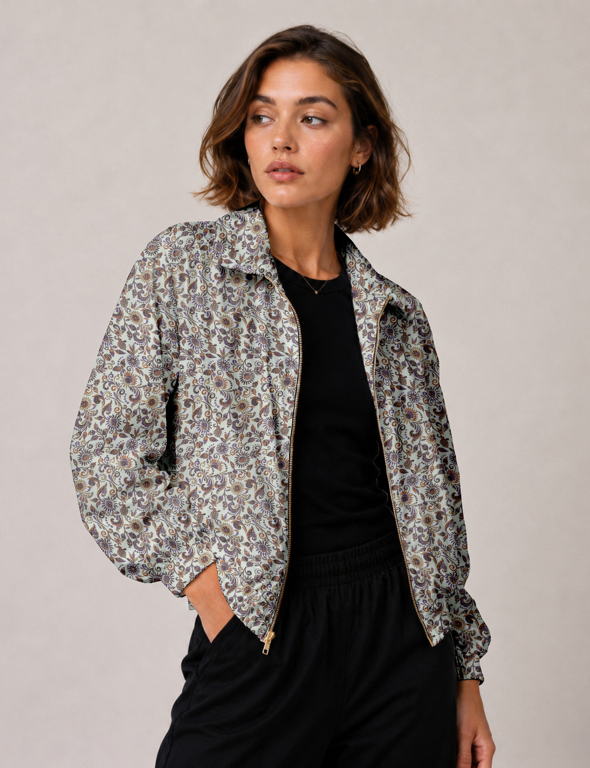 Woman wearing a yellow floral bomber jacket with front zipper, elastic cuffs, and side pockets, shown from front view