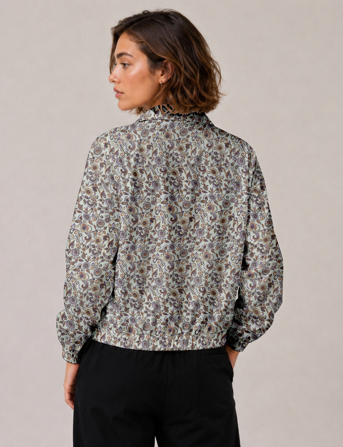 Brown floral bomber jacket with front zipper, elastic cuffs and hem, hanging on white hanger, red floral inner lining visible