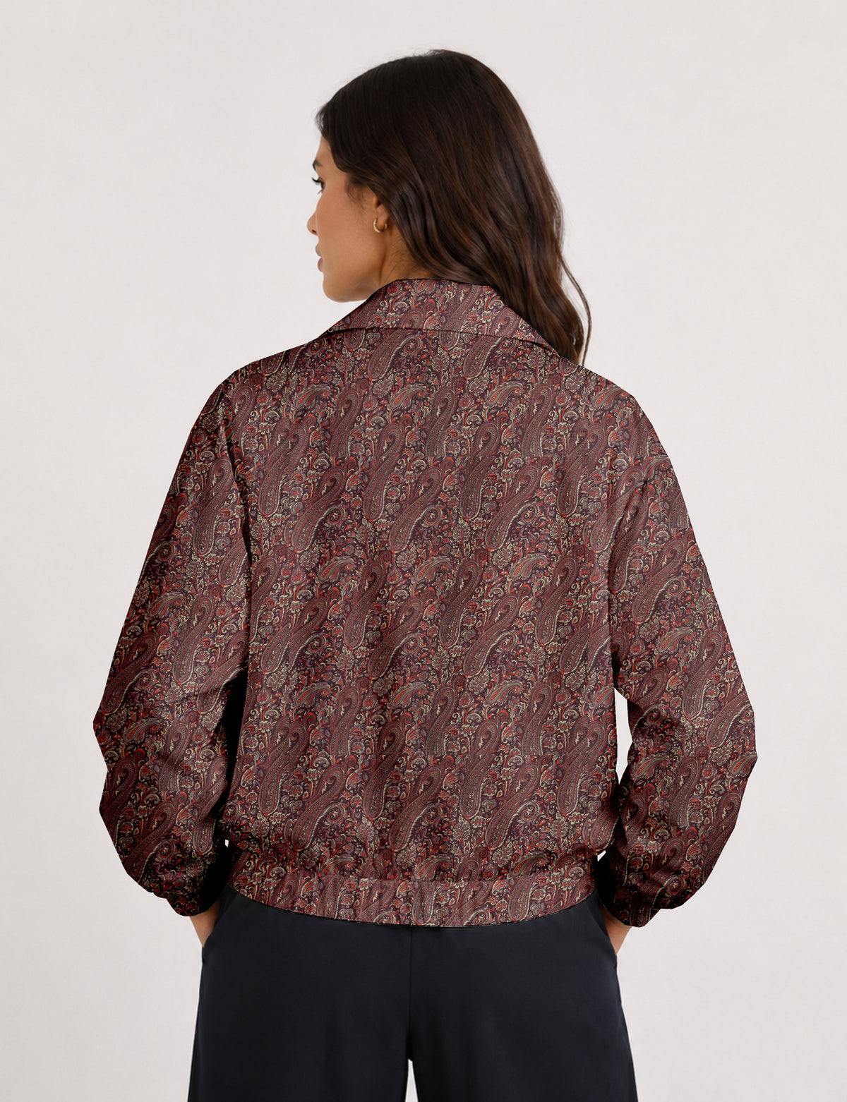 Brown floral bomber jacket with front zipper, elastic cuffs and hem, hanging on white hanger, red floral inner lining visible
